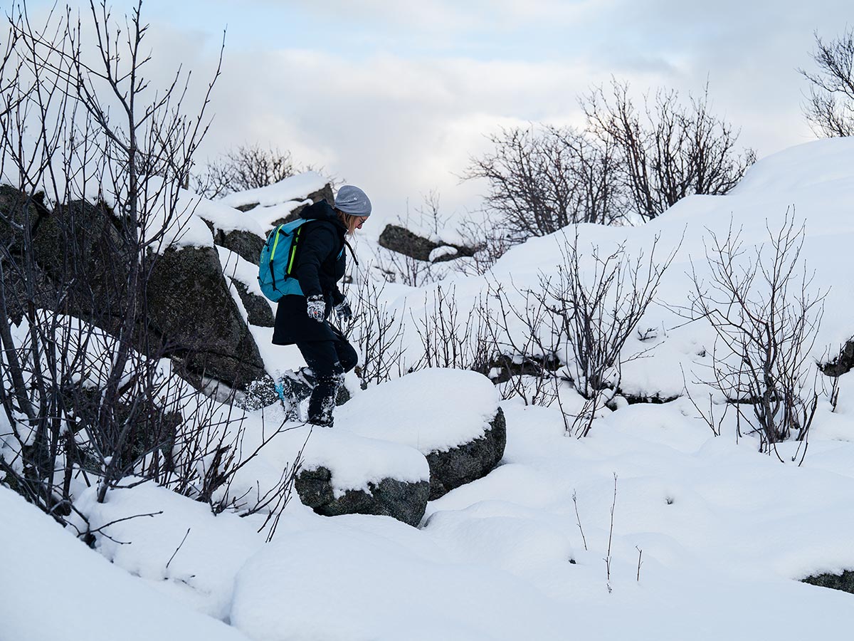 Woman hiking through fresh snow with backpack in Lofoten.