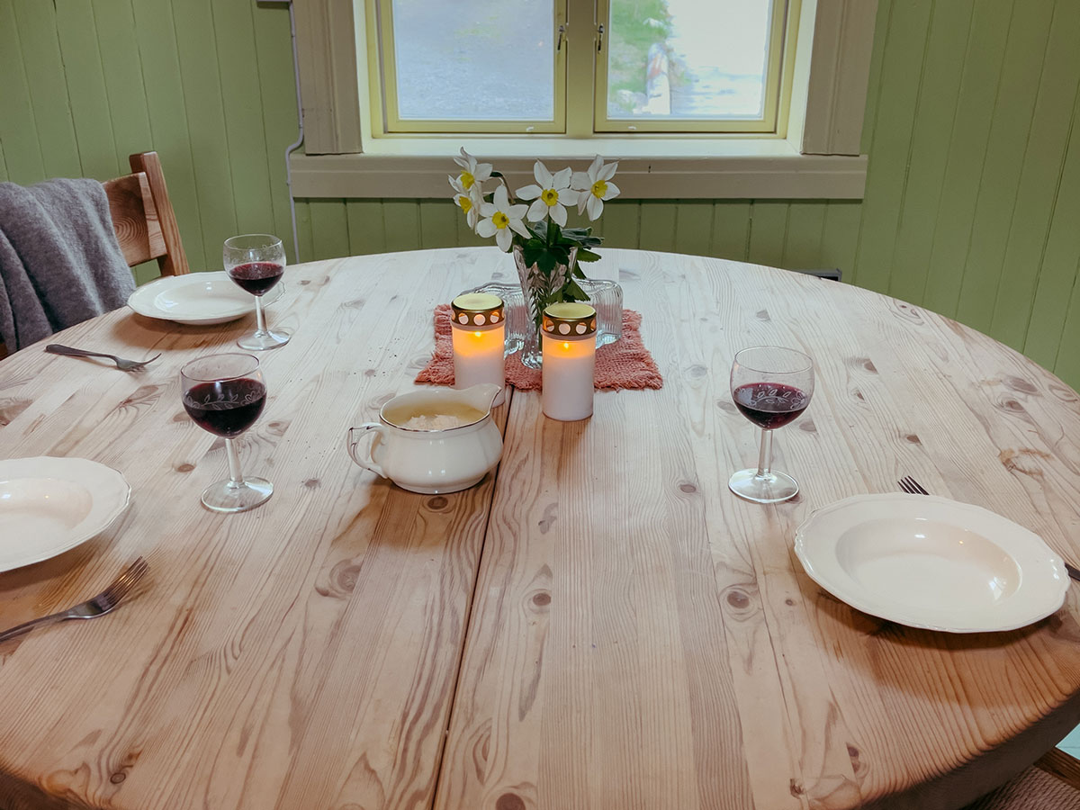 Evening community dinner table with candles and wine at Havly Lofoten Retreat.