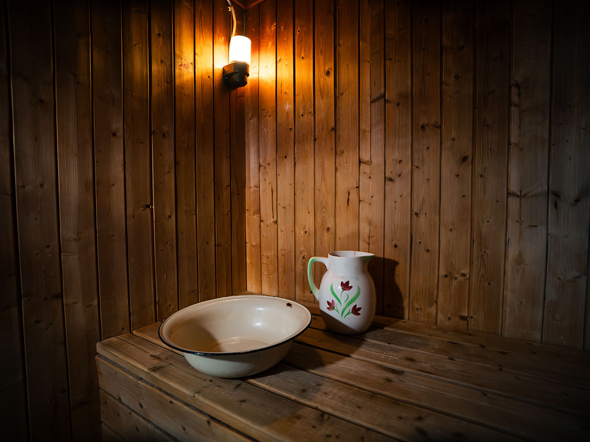 Traditional wooden sauna interior with bowl and jug.